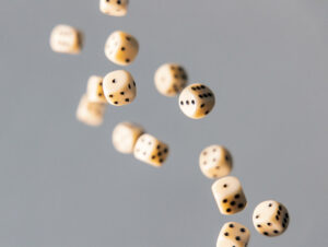 Photo of dice falling against a gray background.