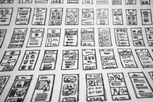 Photograph of a series of illustrations of mobile application screens, possibly mockups for developers.