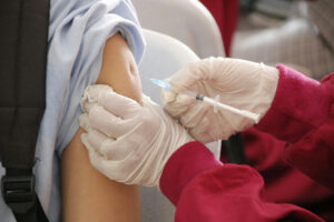Photograph of a school-aged child being vaccinated Photograph of a school-aged child being vaccinated