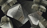 Superimposed photograph of several books with the pages folded into an airplane shape on an infinite black background.