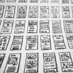 Photograph of a series of illustrations of mobile application screens, possibly mockups for developers.