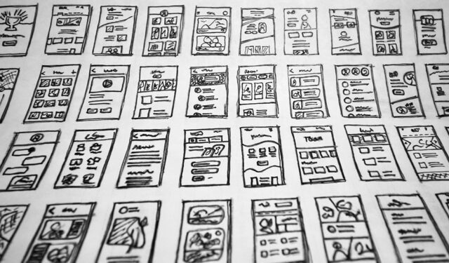 Photograph of a series of illustrations of mobile application screens, possibly mockups for developers.