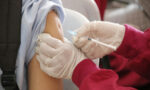 Photograph of a school-aged child being vaccinated
