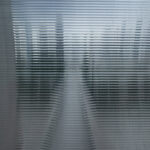 Photograph of a landscape, seen through a ribbed glass pane