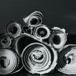 Black-and-white photograph of rolled and stacked papers.
