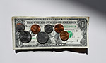 Fotografía de un billete de un dólar sobre una mesa blanca con siete monedas encima.