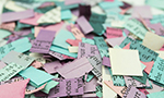 Fotografía que muestra varios trozos de papel de colores triturado.