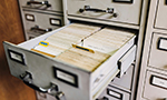 Cajón de archivo abierto con carpetas organizadas separadas por pestañas visibles, mostrando una disposición ordenada de los documentos.