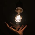 Fotografía de una mano tocando una lámpara.
