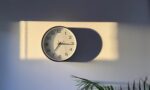 Fotografía de un reloj en una pared bajo la luz del sol
