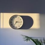 Fotografia de relógio em uma parede sob a luz do sol