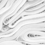 Fotografia de folhas de papel branco enroladas, dispostas em camadas