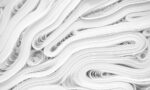 Fotografia de folhas de papel branco enroladas, dispostas em camadas